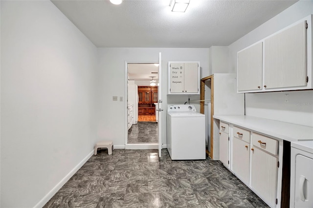 laundry area featuring cabinets, a textured ceiling, and washer / clothes dryer