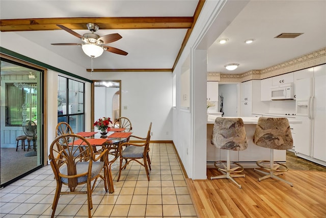 dining room with ceiling fan, beamed ceiling, light tile patterned flooring, and ornamental molding