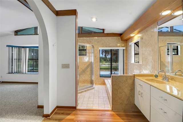 bathroom featuring tile walls, vanity, lofted ceiling, and hardwood / wood-style flooring