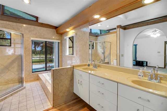 bathroom featuring plus walk in shower, hardwood / wood-style floors, vanity, and ceiling fan