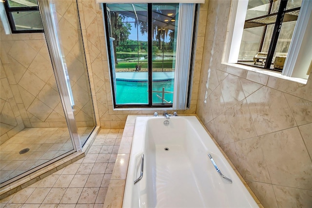 bathroom with a healthy amount of sunlight, tile walls, and shower with separate bathtub