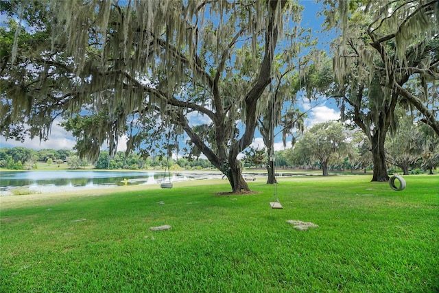 surrounding community featuring a lawn and a water view