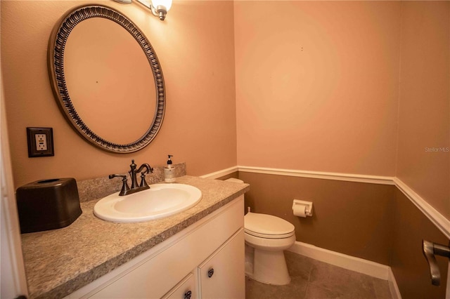 bathroom with tile patterned flooring, vanity, and toilet