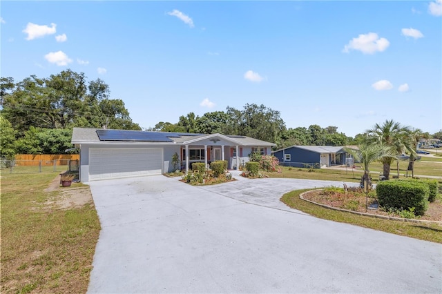 single story home featuring a front yard, solar panels, and a garage