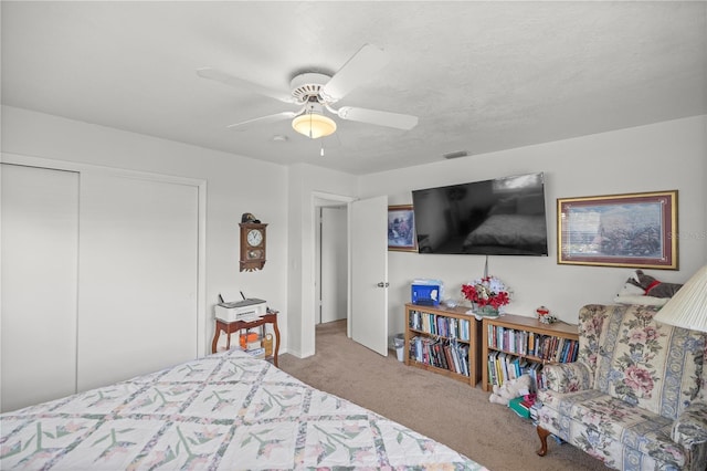 bedroom with ceiling fan, carpet floors, and a closet