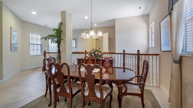 dining space featuring light tile patterned floors and an inviting chandelier