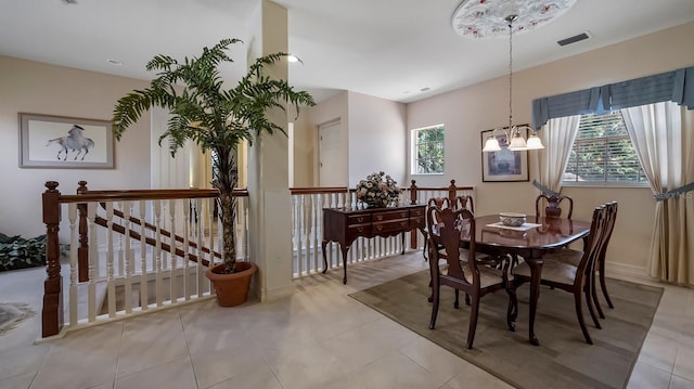 tiled dining room featuring a notable chandelier