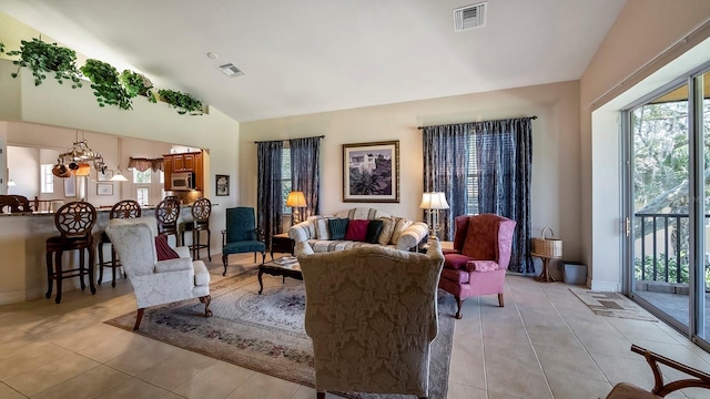 living room featuring lofted ceiling, light tile patterned floors, and a chandelier