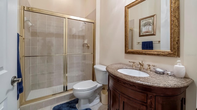 bathroom with vanity, toilet, and a shower with door