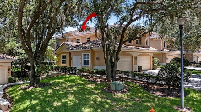 mediterranean / spanish-style house with a front yard and a garage