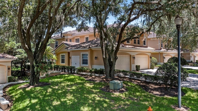 mediterranean / spanish-style house featuring a front lawn and a garage