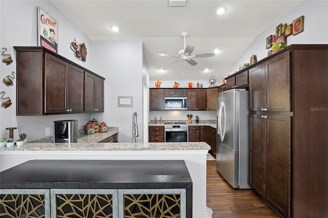 kitchen featuring dark wood-type flooring, kitchen peninsula, ceiling fan, dark brown cabinetry, and stainless steel appliances