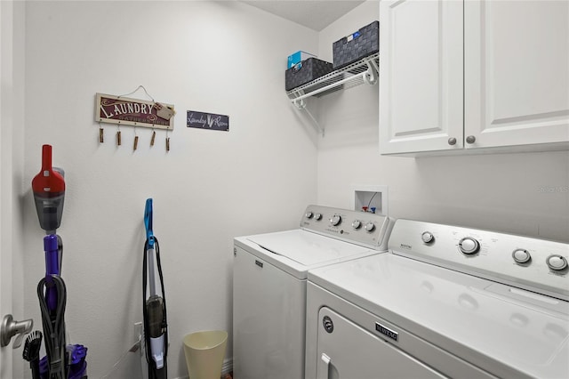 clothes washing area featuring cabinets and independent washer and dryer