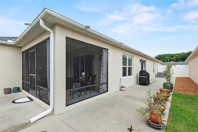 rear view of property featuring a sunroom and a patio area