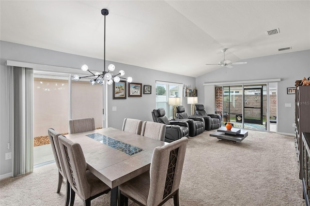 dining area with ceiling fan with notable chandelier, light colored carpet, and lofted ceiling