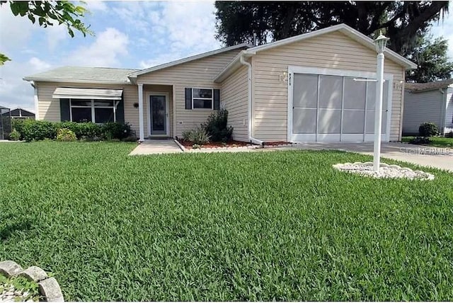 ranch-style house with driveway, an attached garage, and a front yard