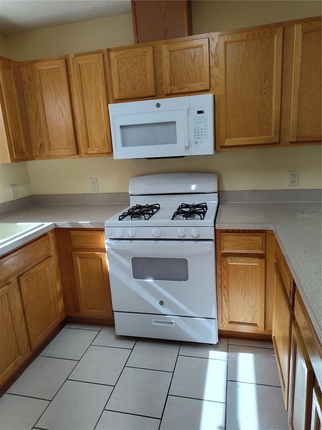 kitchen featuring white appliances and light tile patterned floors