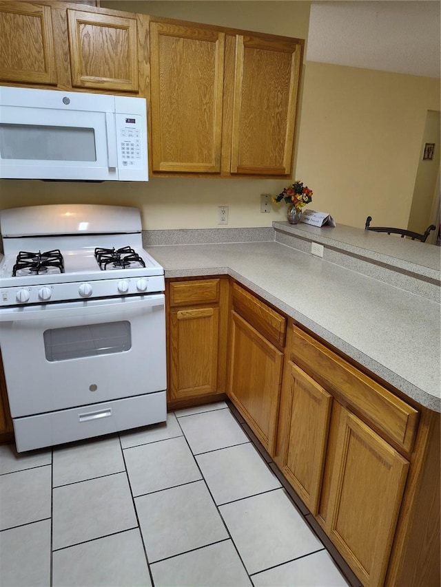 kitchen with white appliances and light tile patterned flooring