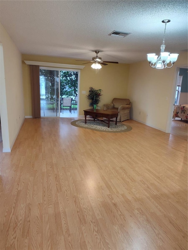 interior space featuring a textured ceiling, light hardwood / wood-style flooring, and ceiling fan with notable chandelier