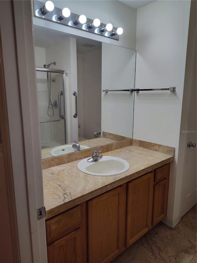 bathroom featuring an enclosed shower and vanity