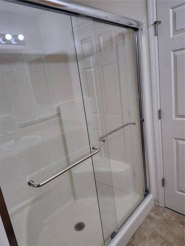 bathroom with a shower with door