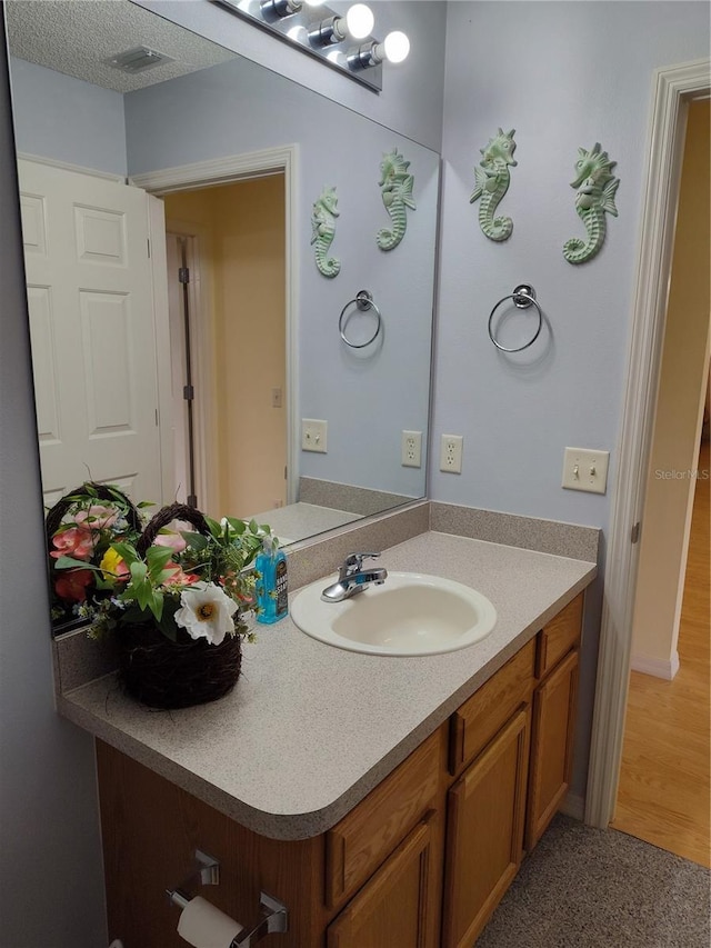 bathroom featuring a textured ceiling and vanity