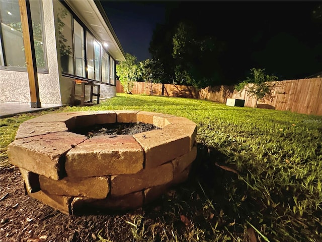 view of yard with a fenced backyard and a fire pit