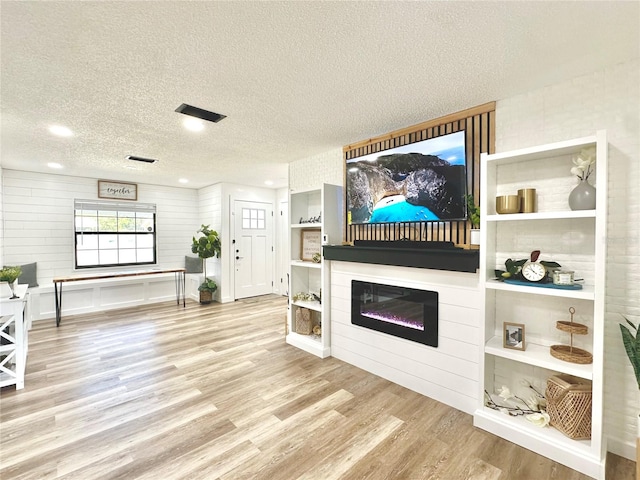 living room featuring light hardwood / wood-style floors and a textured ceiling