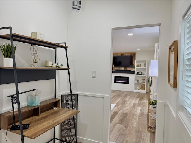 interior space with a wainscoted wall, recessed lighting, visible vents, and light wood-style floors