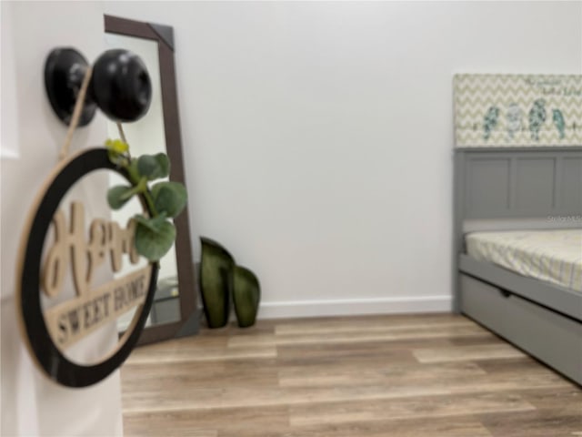 bedroom featuring light wood-type flooring and baseboards
