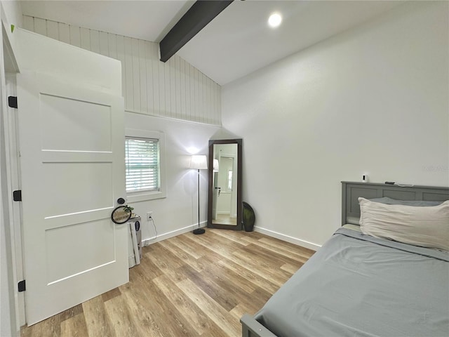 bedroom with light wood-style floors, beam ceiling, high vaulted ceiling, and baseboards