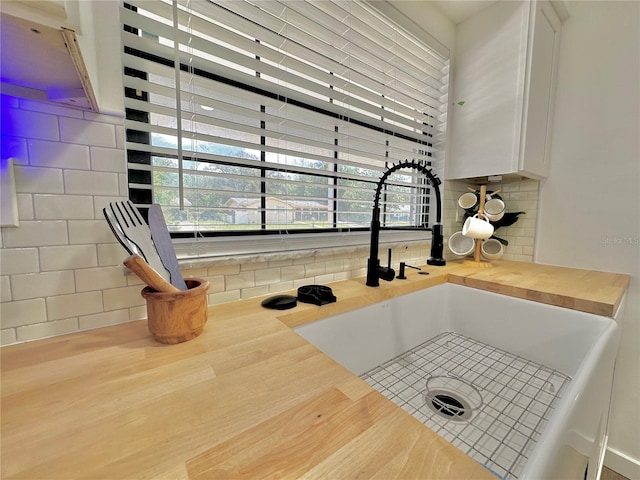 details featuring butcher block counters, decorative backsplash, and a sink