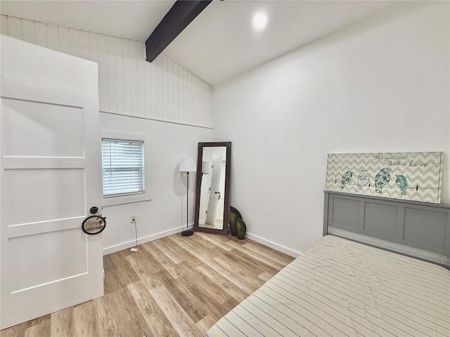 bedroom featuring lofted ceiling with beams, baseboards, and light wood-style floors
