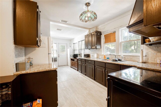 kitchen featuring dark brown cabinetry, plenty of natural light, and sink