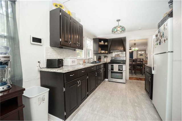 kitchen with tasteful backsplash, white fridge, decorative light fixtures, stainless steel electric range, and custom exhaust hood