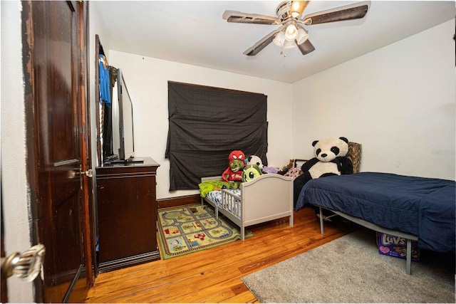 bedroom with ceiling fan and hardwood / wood-style flooring