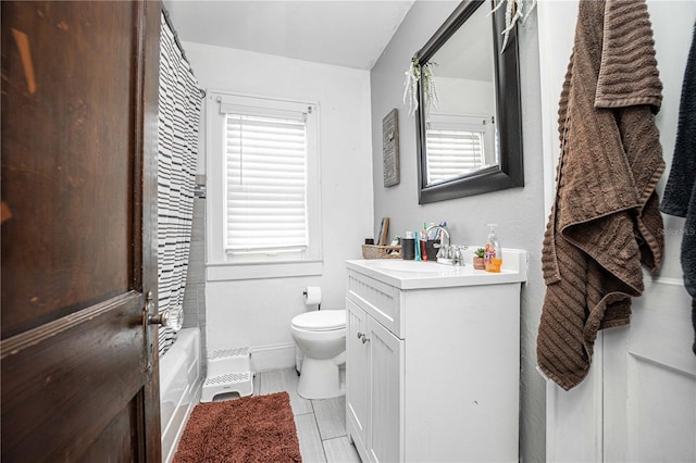 full bathroom featuring shower / bathtub combination with curtain, a wealth of natural light, vanity, and toilet