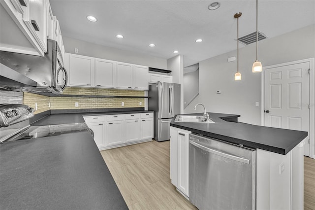 kitchen with white cabinetry, sink, hanging light fixtures, decorative backsplash, and appliances with stainless steel finishes