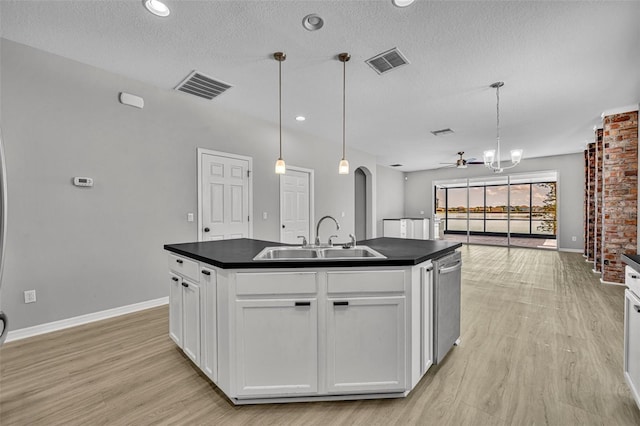 kitchen with white cabinetry, sink, hanging light fixtures, light hardwood / wood-style flooring, and a center island with sink