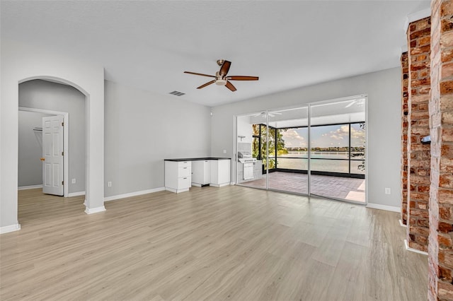 unfurnished living room with light hardwood / wood-style flooring and ceiling fan