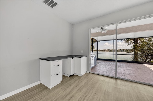 interior space with a water view, ceiling fan, and light hardwood / wood-style floors