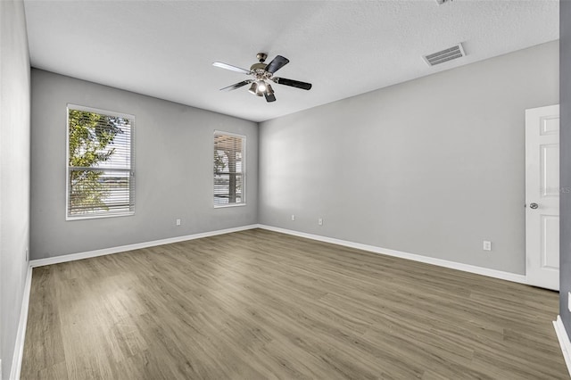 spare room featuring ceiling fan, wood-type flooring, and a textured ceiling