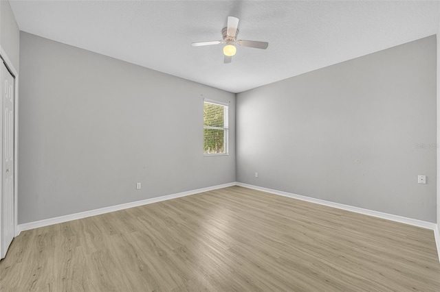 empty room featuring ceiling fan and light hardwood / wood-style flooring