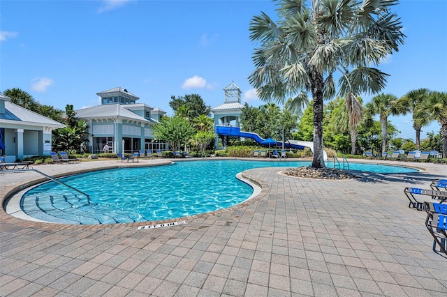 view of swimming pool with a patio area and a water slide