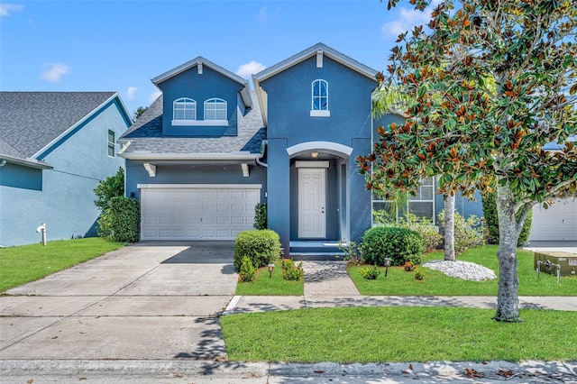 view of front property featuring a garage and a front lawn