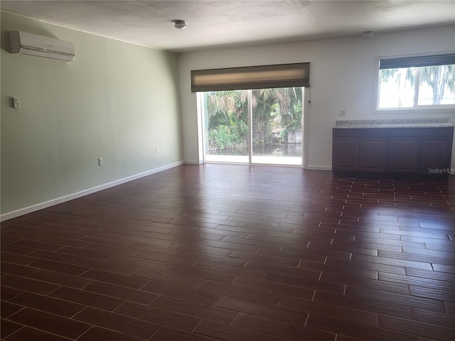 empty room featuring dark wood-type flooring and a wall unit AC