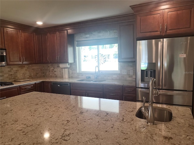 kitchen with light stone countertops, sink, and black appliances