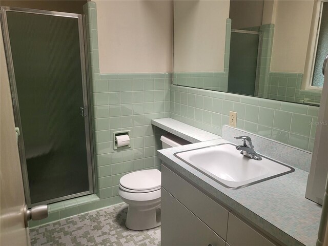 bathroom featuring vanity, tile walls, an enclosed shower, and toilet