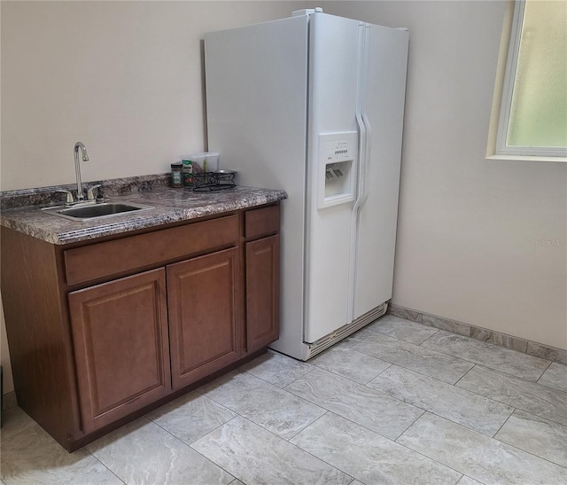 kitchen with white refrigerator with ice dispenser and sink