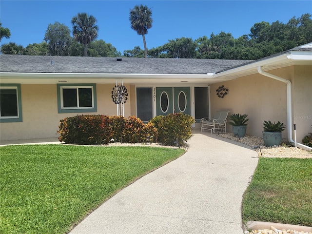 entrance to property with a yard and a porch